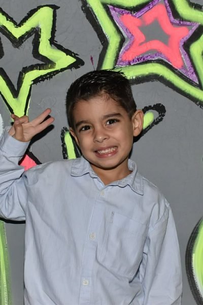Kid Smiling in birthday party in front of a neon wall in Neon Disco Lets Dance in Peristeri, Athens
